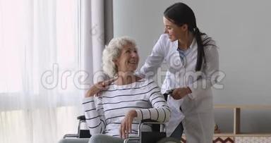 一位年轻的女护士员在轮椅上帮助<strong>年迈</strong>的祖母